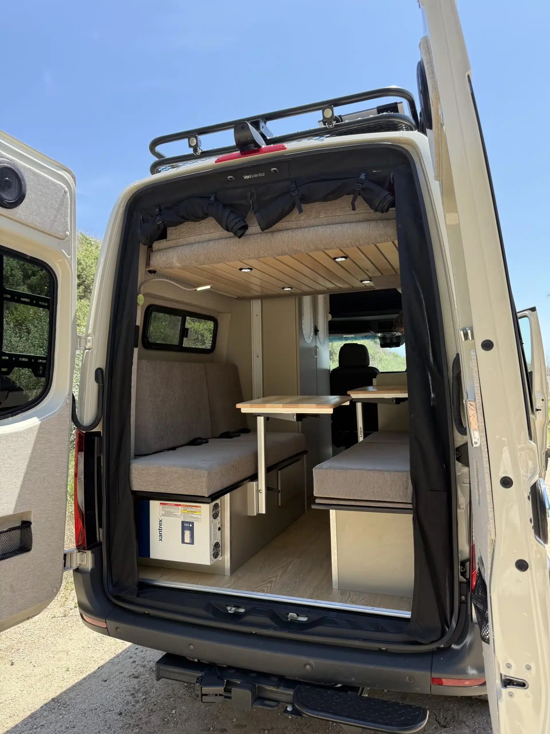 Wohnbereich und Sitzgruppe des Trail Hob Campers von hinten fotografiert, mit Tisch und Sitzbänken im Mercedes Sprinter.