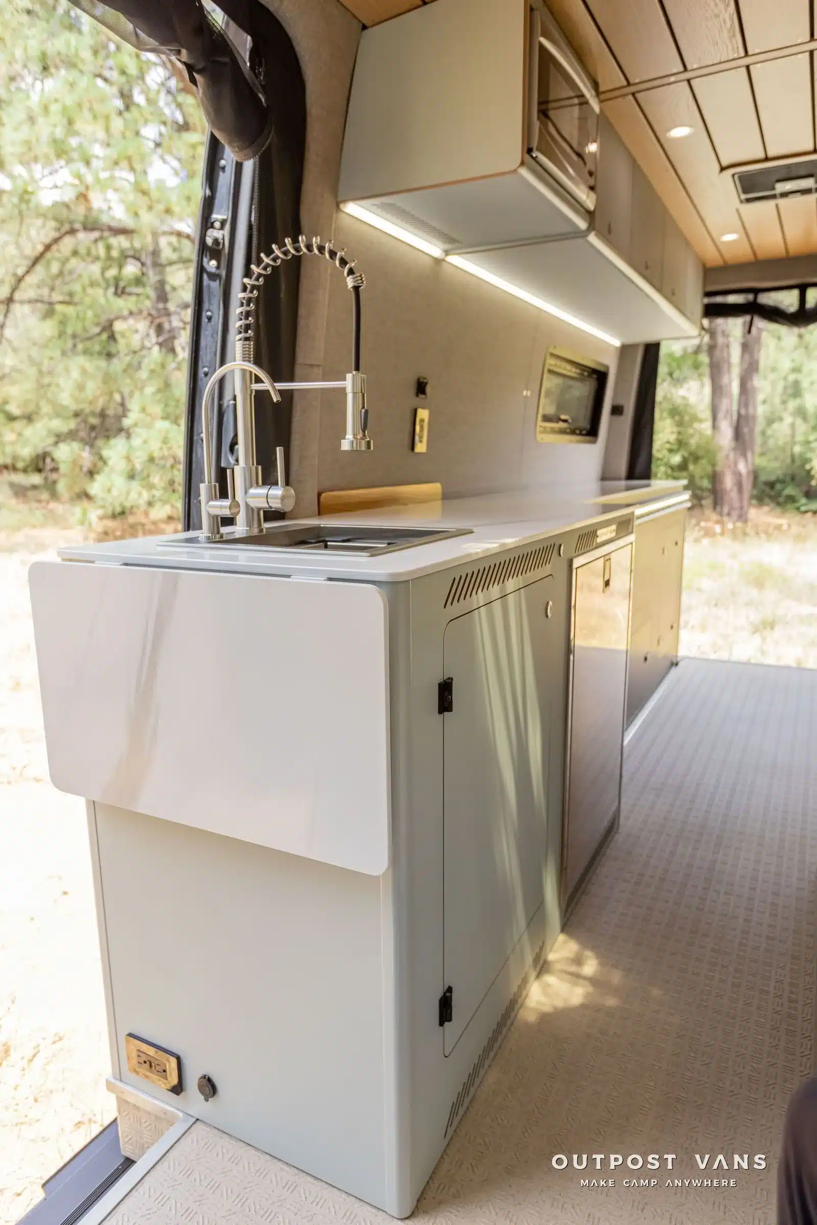 Innenansicht des Küchenblocks mit Spüle und moderner Ausstattung im UNCHAINED Sprinter Campervan