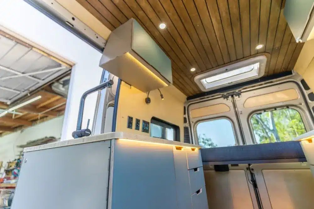 Modularer Innenausbau eines Avalon-Campervans mit Küche, Oberlichtern und Futon-Bett.