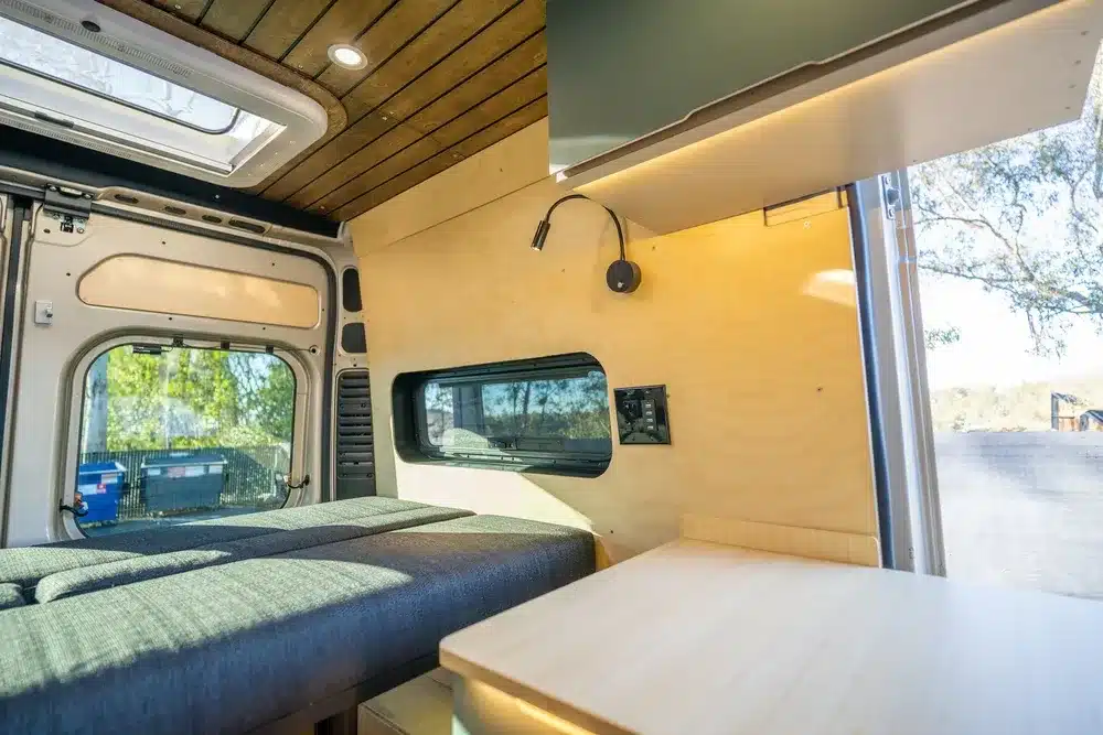 Blick in den Innenraum eines ausgebauten Kastenwagens mit Futon-Bett, Holzdecke und Holzverkleidung, Avalon-Modell