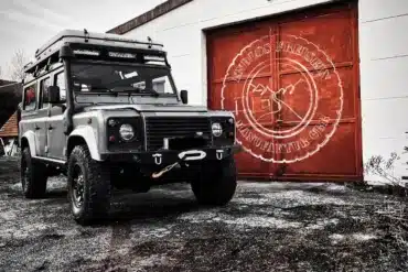 Land Rover Defender 110 mit Dachzelt und Offroad-Umbau vor der Werkstatt Endlos Freistehen Manufaktur