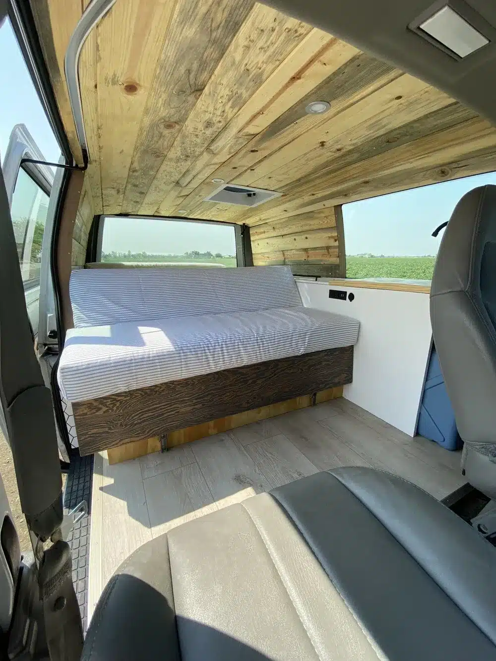 Moderner Innenausbau des Brooklyn J69JL Campervans mit Holzdecke, flexiblem Bettsofa und lichtdurchflutetem Wohnbereich.