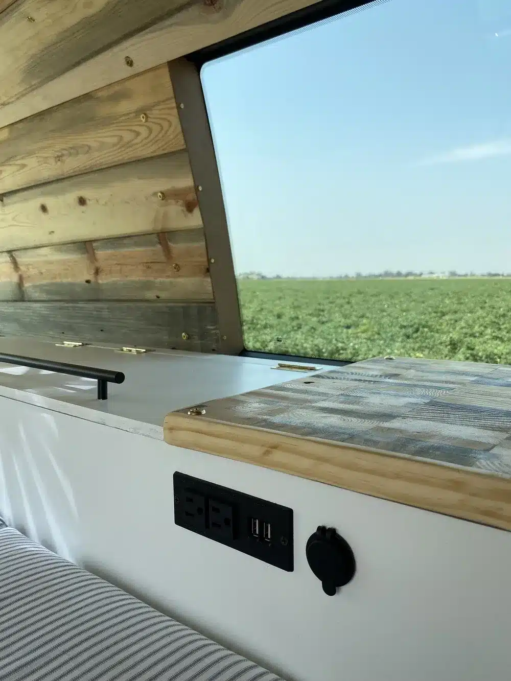 Innenansicht im Campervan Brooklyn J69JL mit Steckdosen, USB-Anschlüssen und moderner Holzverkleidung