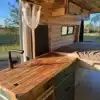 Campervan-Innenraum mit Holzverkleidung, Küchenarbeitsfläche, Stauraum und Bett im Coastal Cruiser.
