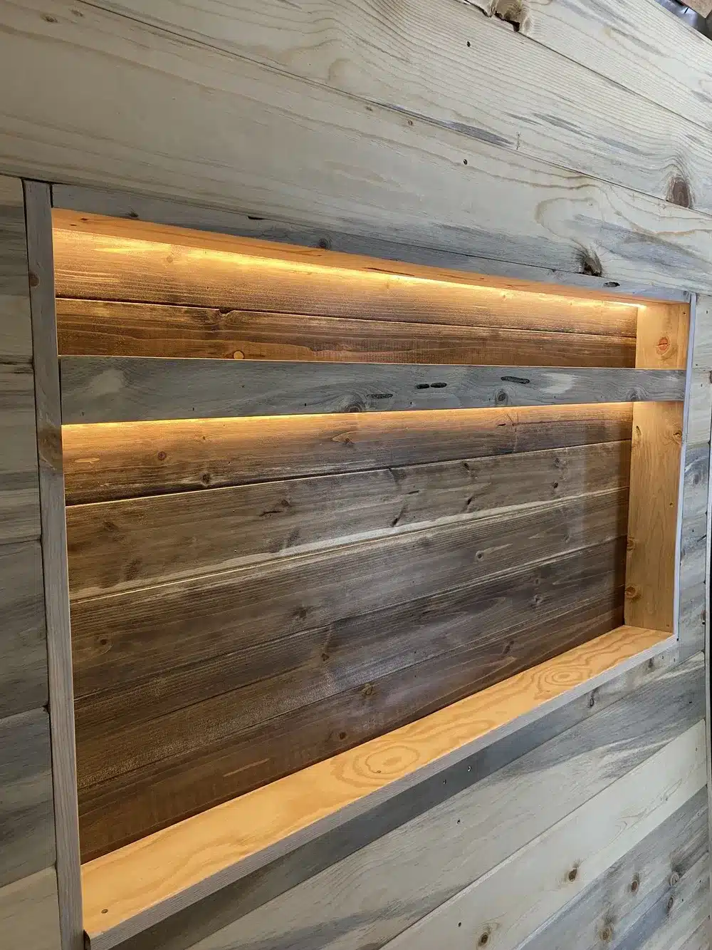 Holzregal mit integrierter Beleuchtung im Innenraum eines Campervans Yolo Cozy Cabin