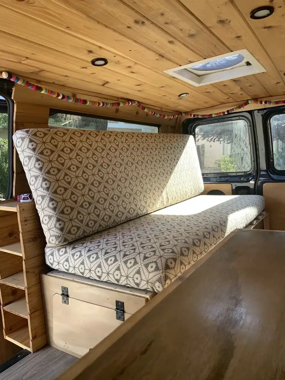 Innenausbau des Donovan Campervans mit Sitzbank, Holzdecke und praktischem Stauraum.