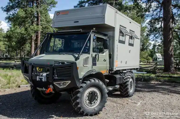 Expeditions-Lkw mit 11-Fuß-Wohnkabine von Bliss Mobil auf Offroad-Gelände, mit Aluminiumrahmen und großem Stauraum.