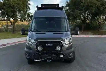 Frontansicht eines individuell ausgebauten Ford Transit 350 HR PASS XL AWD Vans aus dem Modelljahr 2022 mit Overland-Ausstattung.