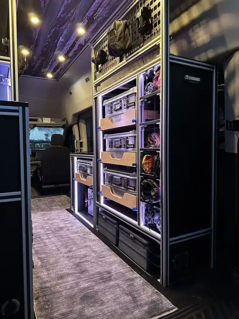 Innenraum mit Stauraum, Regalsystem und LED-Beleuchtung im Overland-Ausbau eines 2022 Ford Transit 350 HR PASS XL AWD.