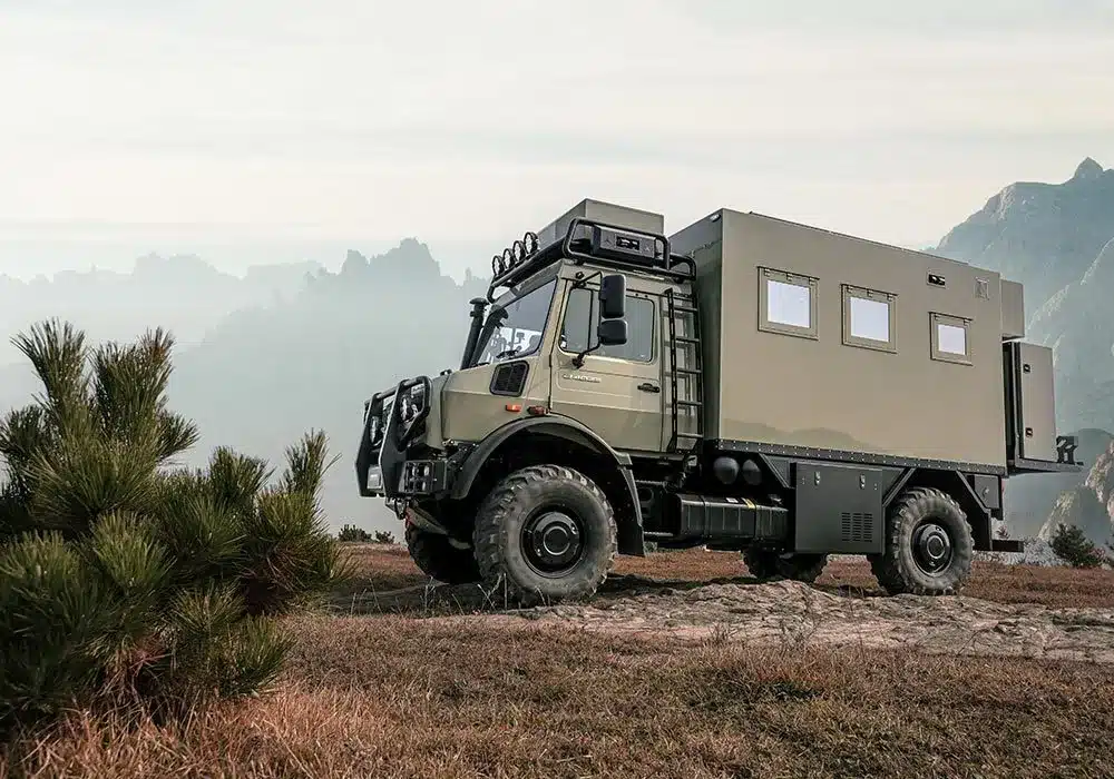 Der 2025 U3 Unimog Expedition Camper abseits befestigter Straßen in einer Gebirgslandschaft.