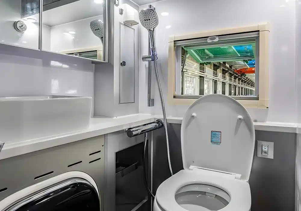 Innenansicht des Badezimmers mit Toilette, Waschbecken und Dusche im Unimog Expedition Camper