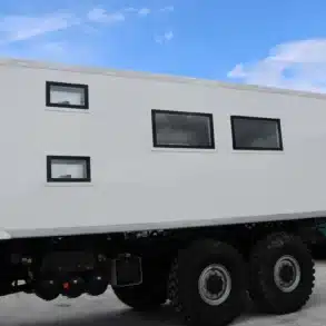 Vorgefertigte Expeditions-Wohnkabine montiert auf einem geländegängigen Lkw-Fahrgestell, Außenansicht mit mehreren Fenstern.