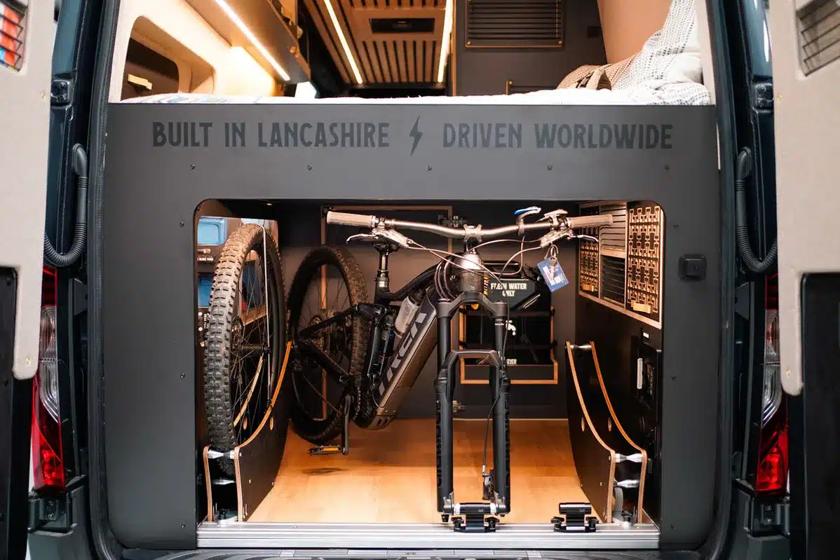 Heckbereich eines ausgebauten Mercedes-Benz Sprinter Beyond4 mit großem Stauraum und Fahrradhalterung