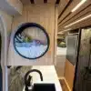 Blick in den Küchenbereich eines Black Rhino MINI 2A MAX Offroad-Caravans mit moderner Einrichtung, Pflanzen und Stauraum.