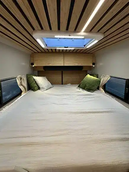 Innenansicht eines Black Rhino MINI 2A MAX Offroad-Caravans mit großem Bett, Holzdecke und Oberlicht