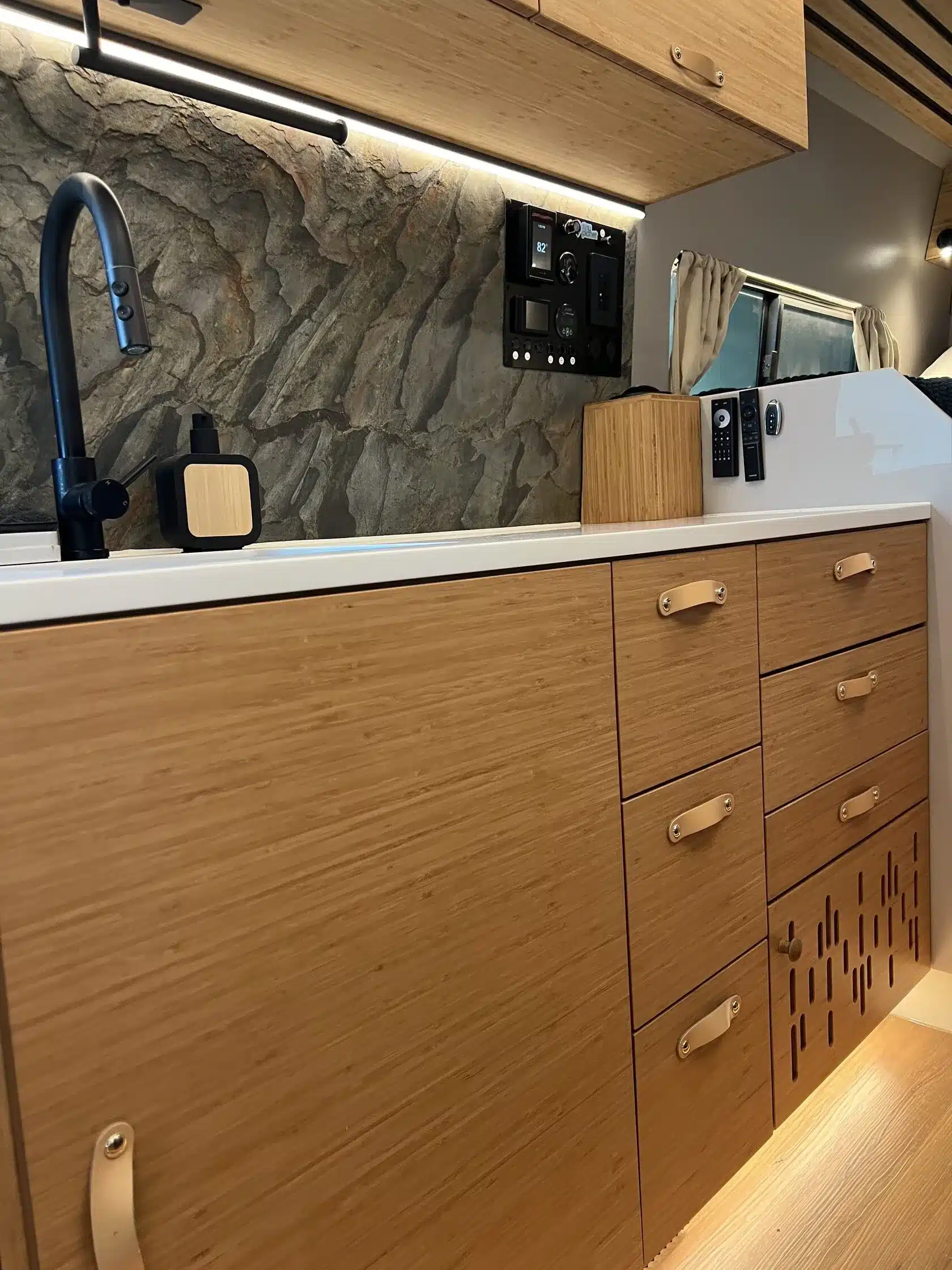 Kompakte Innenraum-Küche mit Holzoptik, moderner Armatur und Bedienfeld im Black Rhino MINI 2A MAX Caravan