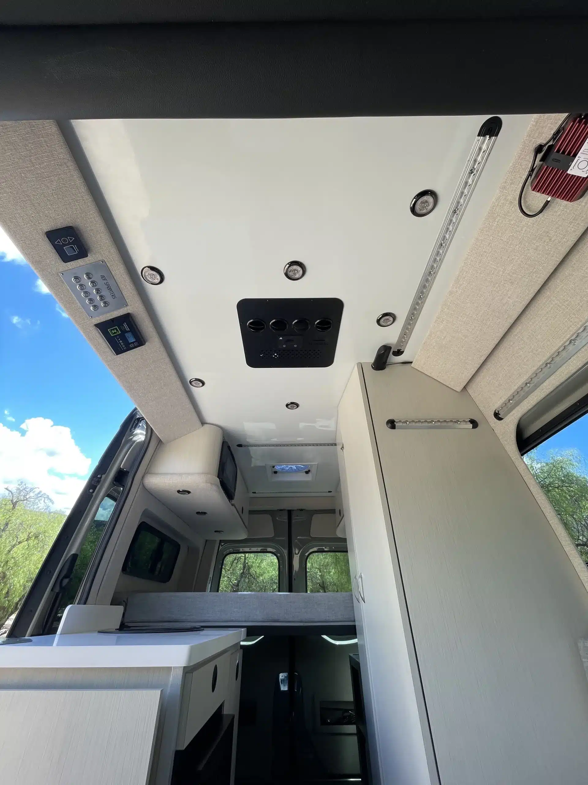 Innenansicht des Burn Campervans mit Küchenzeile, hellem Ausbau und festen Staumöglichkeiten auf Sprinter 4x4-Basis.