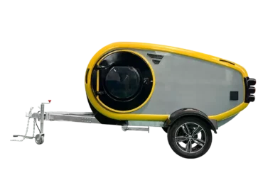 Seitenansicht des gelb-grauen Comma CE Teardrop-Campers mit runden Formen und Offroad-Bereifung