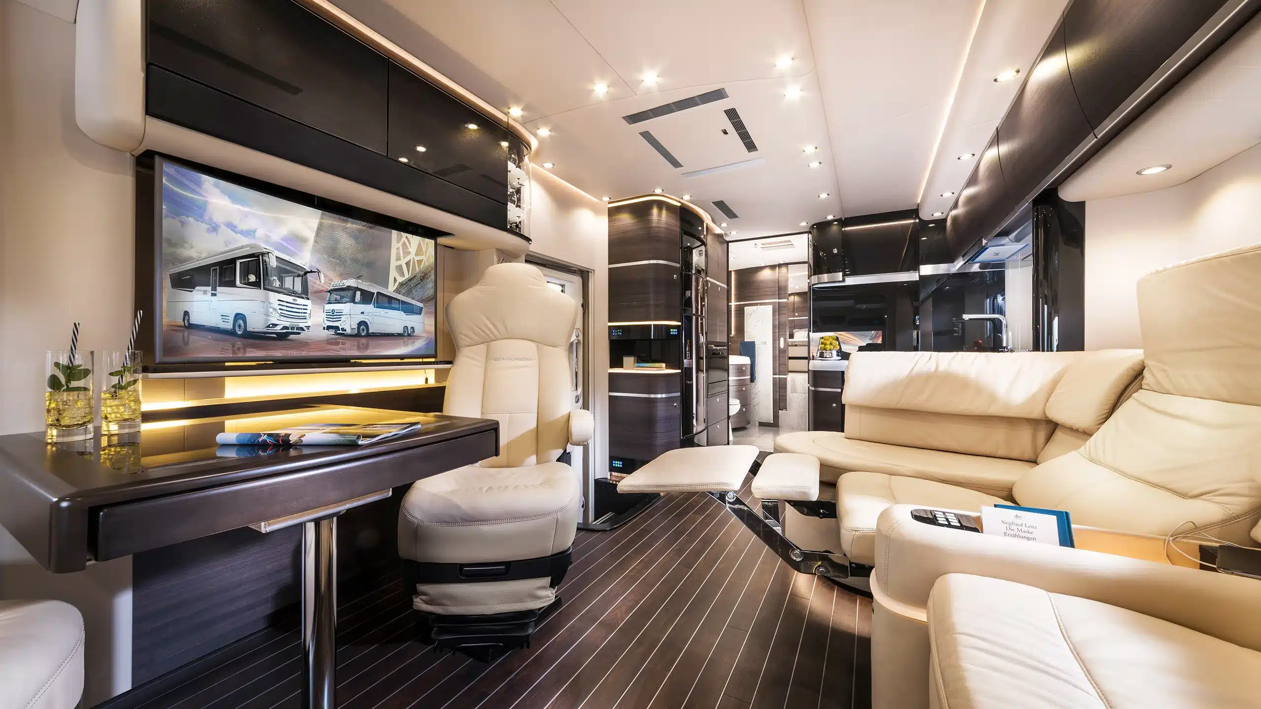 Luxus-Innenraum des Concorde Centurion Actros mit Ledersofa, Relax-Sessel, Tisch und Multimediasystem