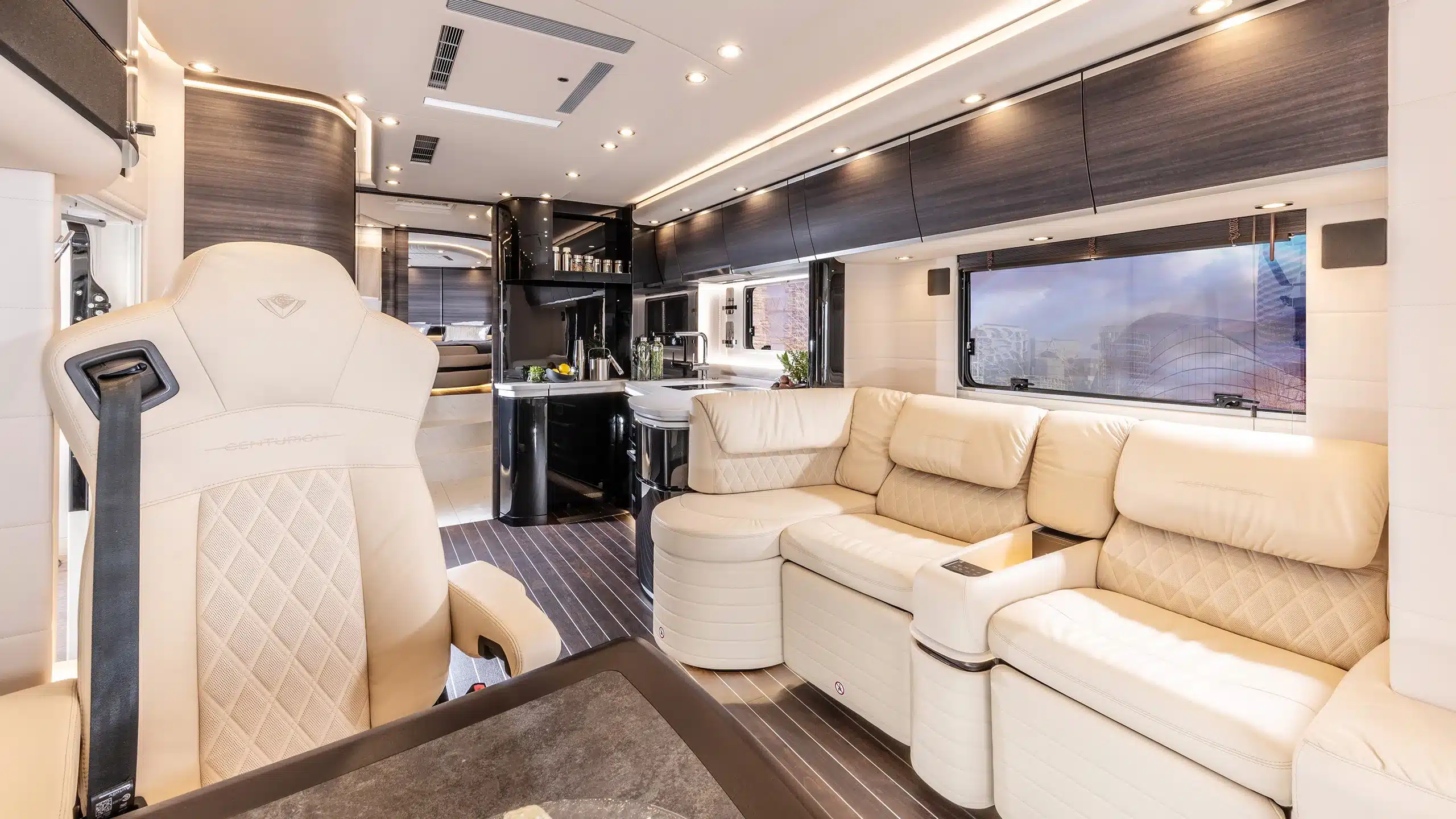 Innenraum eines Concorde Centurion Actros mit beigen Ledersesseln, moderner Küche und stilvoller Lounge.