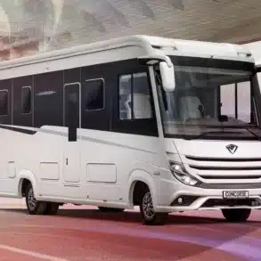 Vollintegriertes Luxus-Reisemobil Concorde Charisma auf einer Straße unter einer modernen Brücke