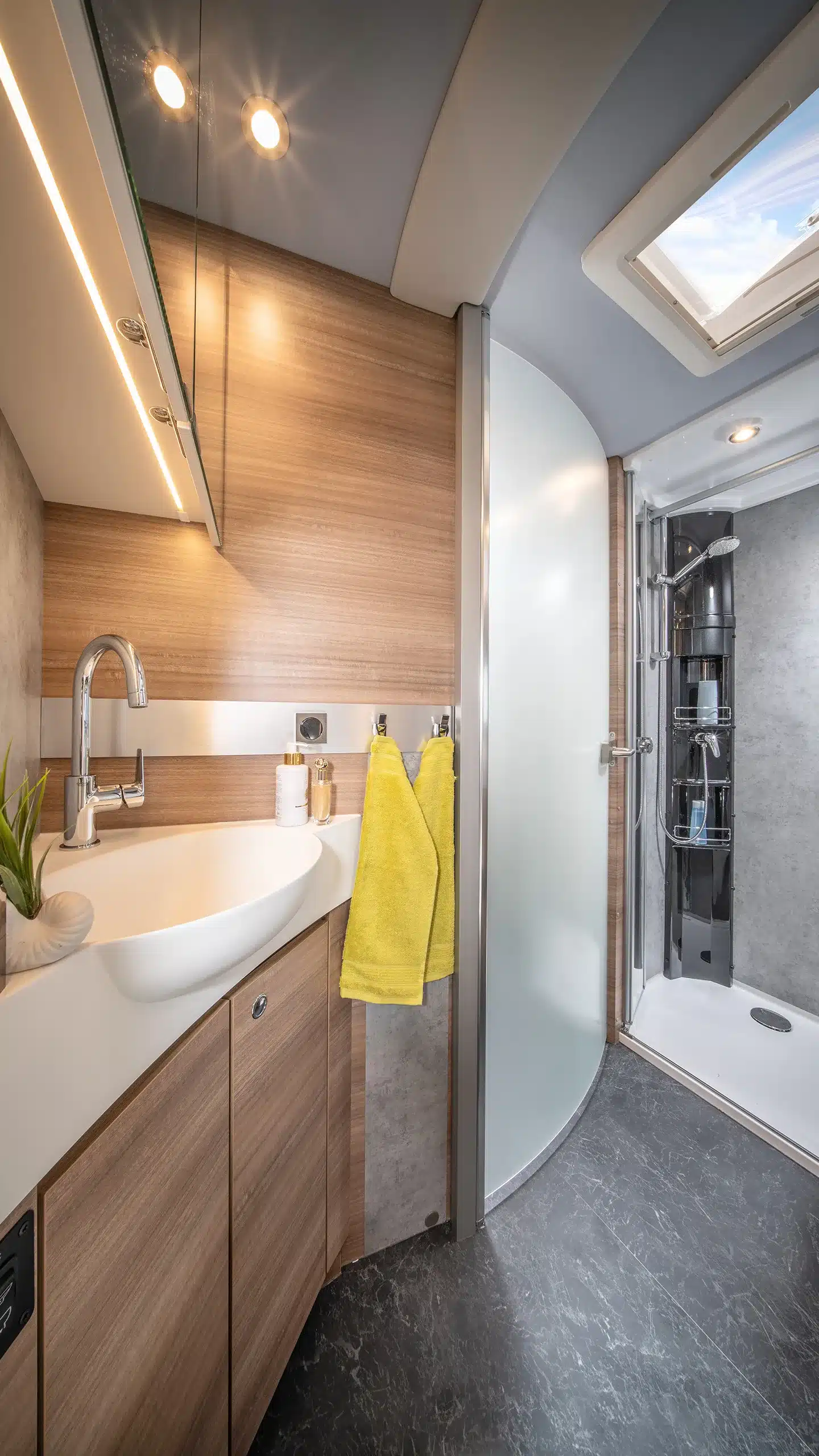 Badezimmer mit Waschtisch, Spiegel und separater Duschkabine in der Concorde Credo Graphite Edition