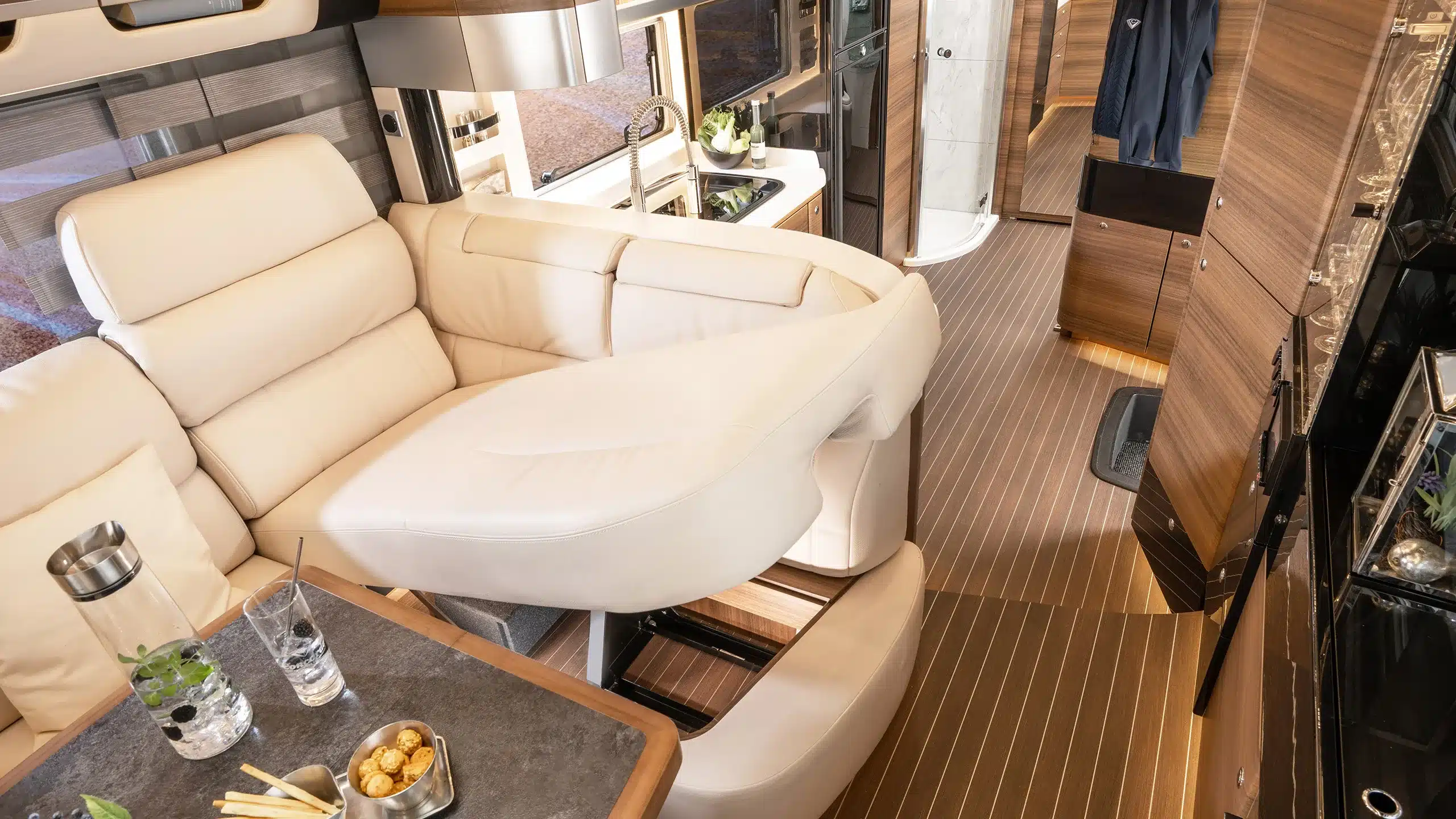 Innenansicht des Concorde Cruiser Atego mit luxuriöser Sitzlounge, Küche und modernen Möbeln aus Holz