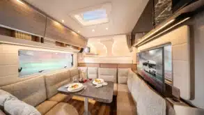 Der Wohnbereich mit Rundsitzgruppe und Alkovenbett im Concorde Cruiser Daily Reisemobil