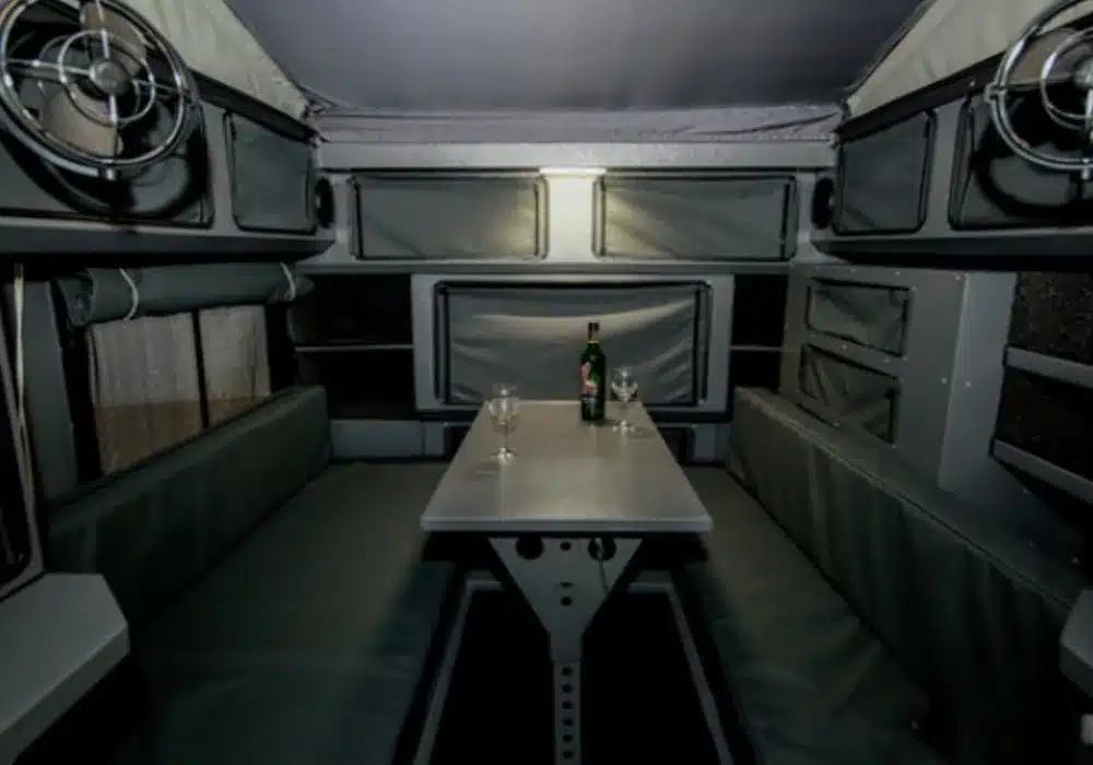 Innenansicht des Conquer Off-Road Trailer 490 mit Sitzbänken und Tisch