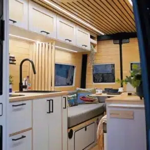 Innenausbau des Beyond 2 Sprinter-Campers mit hochwertiger Küche, Sitzbank und Holzpaneeldecke