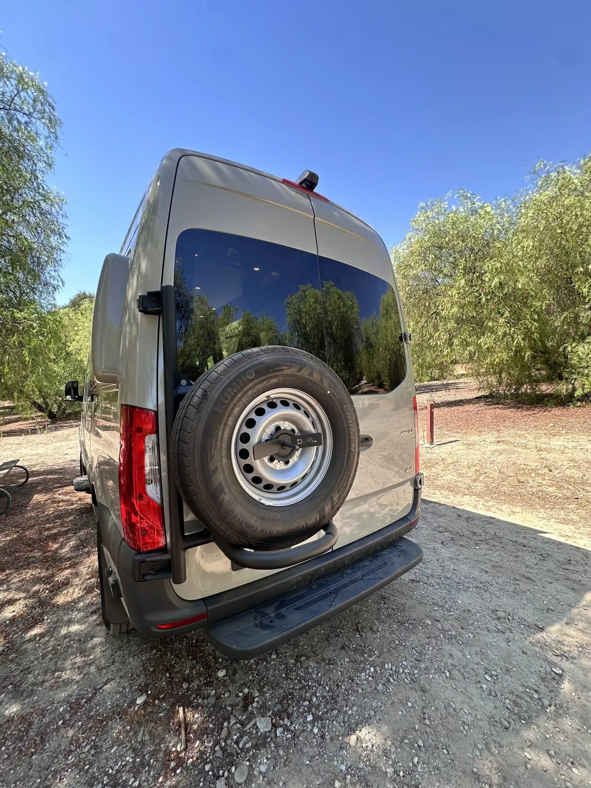 Heckansicht eines Mercedes Sprinter Campervans mit Reserveradträger im Outdoor-Einsatz, geeignet für barrierefreies Reisen.