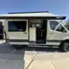 Seitliche Ansicht eines Jet Adventure Vans mit ausgefahrener Markise und geöffneten Türen.