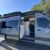 Excursion 4x4 Campervan auf Mercedes Sprinter, seitlich mit geöffneter Tür und sichtbarem Innenausbau.