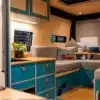 Blick in den maßgeschneiderten Innenraum eines Mercedes-Benz Sprinters mit moderner Küche, Sitzgruppe und Dusche
