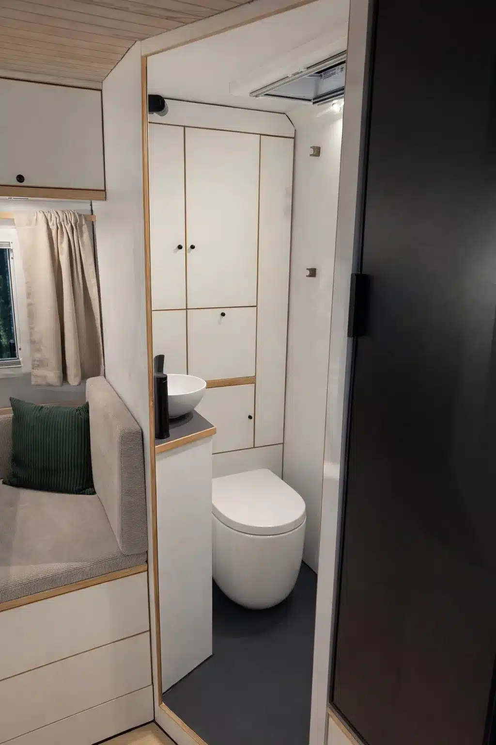 Innenansicht des Badezimmers im Greenlander Sherpa Expeditionsmobil mit Toilette, Waschbecken und Schränken.
