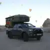 Pickup mit Hotomobil Gladiator Wohnkabine steht im Freien, im Hintergrund steigen zahlreiche Heißluftballons auf