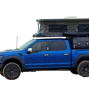 Pickup mit aufgebautem INNature Black Stone Ilmenite Pop-up-Truck-Camper und ausgefahrenem Hubdach auf einem blauen Fahrzeug.