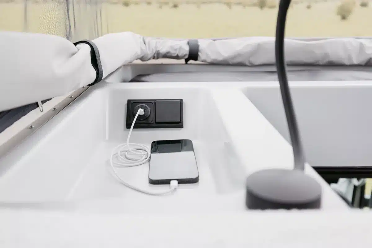 USB-Ladestation mit Smartphone im Innenraum des IPAR Norantz Campervans