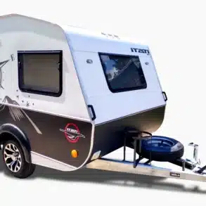 Der ITATI 240 TFi Wohnwagen steht auf einem hellen Hintergrund, zeigt moderne Dekorelemente und ein Reserverad an der Deichsel.