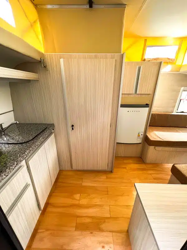 Innenraum des Itati 380 TLi Caravan mit Küchenzeile, Kühlschrank und Sitzbank