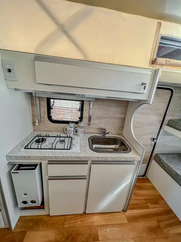 Kompakte Küchenzeile mit Gaskocher, Spüle und Schränken im Itati 460 TLi Caravan