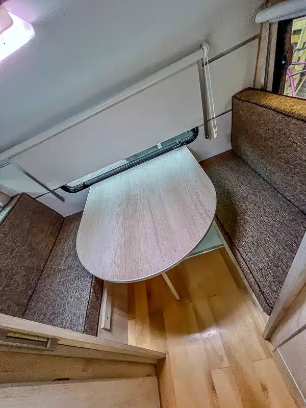 Essbereich mit zwei Sitzbänken und Holzoptik-Tisch im Itati 460 TLi Caravan.