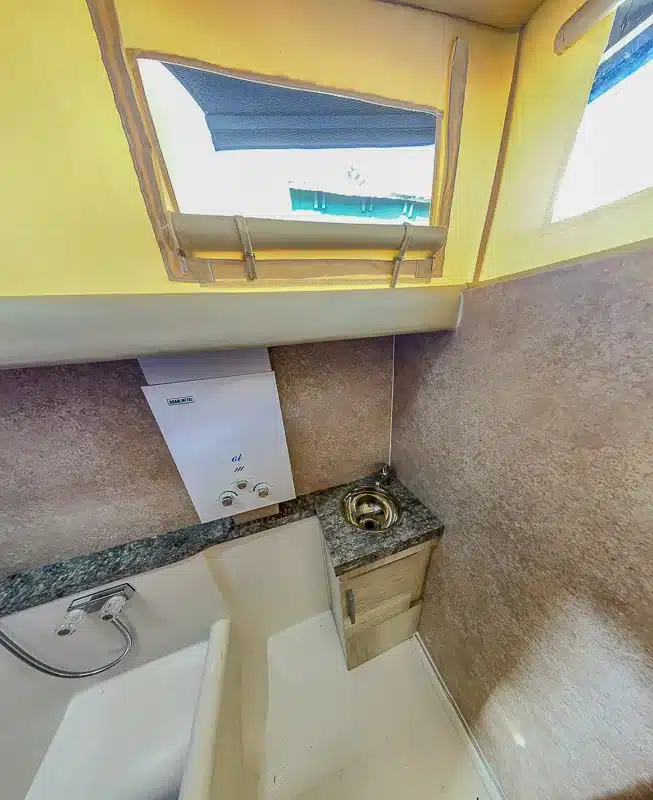 Badezimmer mit Gaskombiheizer, Edelstahl-Spülbecken und Fenster im Caravan Itati 460 TLi