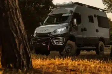 Expeditionsfahrzeug Iveco Daily 4x4 L3H2 im Gelände zwischen Bäumen, aufgenommen bei Sonnenuntergang