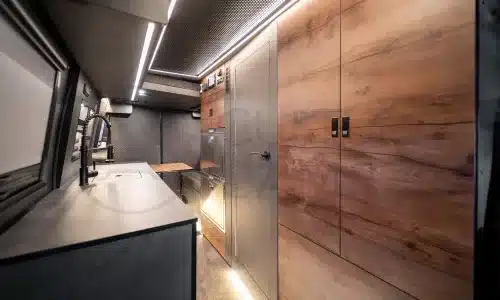 Moderner Innenausbau eines Iveco Daily 4x4 Campers mit Küchenzeile, Sitzgruppe und Stauraum.