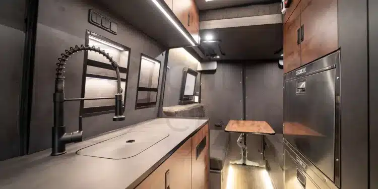 Innenansicht eines hochwertigen Camper-Ausbaus auf Basis des Iveco Daily 4x4 mit Küchenblock, Sitzgruppe und Einbauschränken