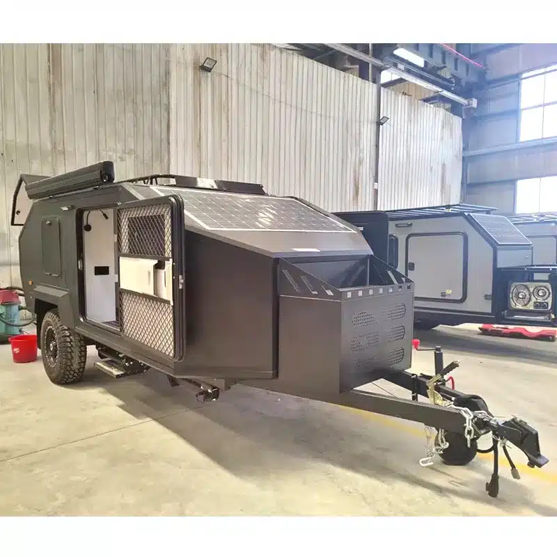 JR Black Rhino 2A Offroad-Campinganhänger mit Solarpanel und markanter Aluminiumstruktur in einer Industriehalle.