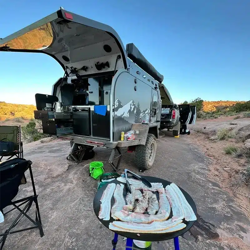 JR Black Rhino VIC Off-Road Camper mit geöffneter Outdoor-Küche im Gelände.