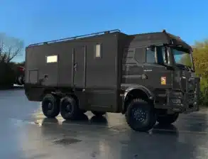 Schweres Allrad-Expeditionsmobil MAN TGS 33.520 6x6 mit großem Wohnkoffer auf Asphaltfläche.