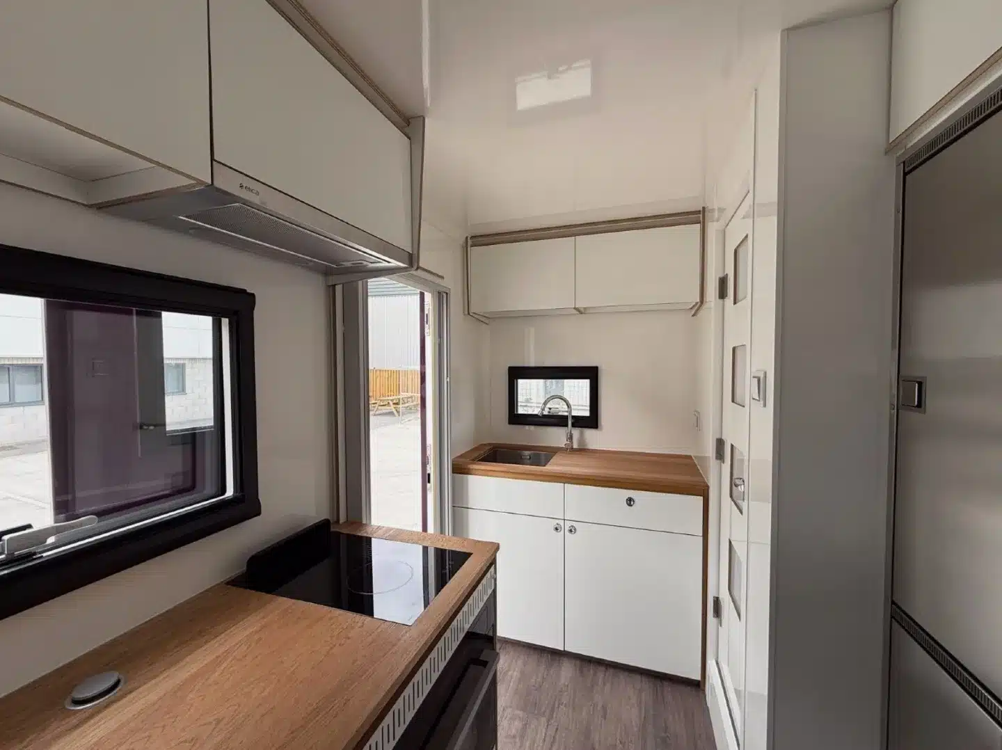 Küche im Wohnaufbau eines MAN/VW 8.136 Expeditions-Lkw mit Holzarbeitsplatten und Einbaugeräten.